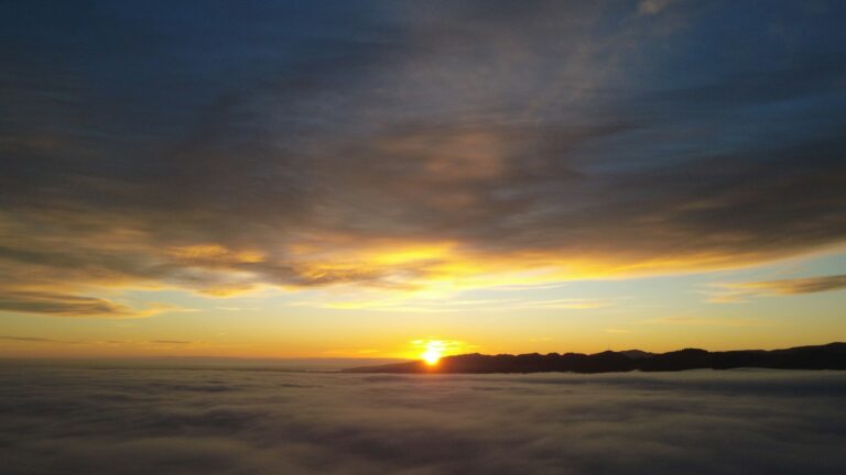 Adonai lyrics - sunrise over a sea of clouds with distant hills
