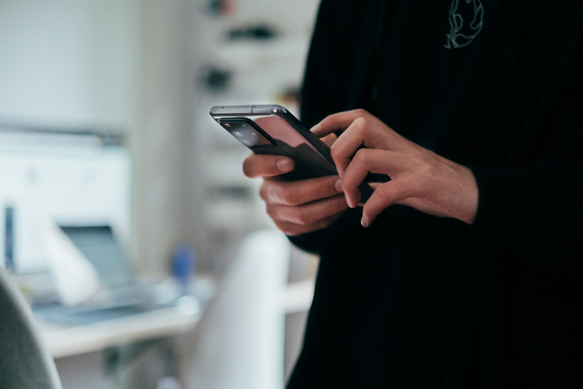 Person holding a smartphone while following consumer electronics news today