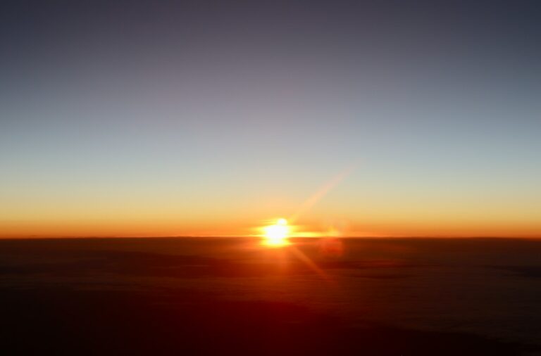 New Thing Coming lyrics - sunrise over clouds under a clear blue sky